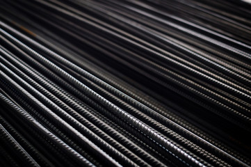 Close up of iron armature rod steel rolled stacked pile background. industrial texture construction concept. Copy space. Stack of heavy metal grey color reinforcing bundle bars, technology pattern