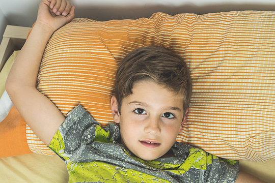 Child Lying In Bed With Eyes Open