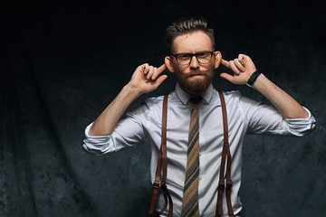 Young stylish hipster businessman or manager is stretching his ears, imitating monkey in a funny...