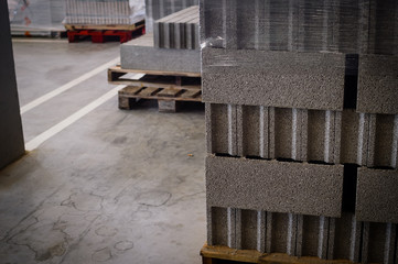 Motion blur image of cement building blocks stacked piled in warehouse background, closeup fabric plant manufacture grey textured abstract surface