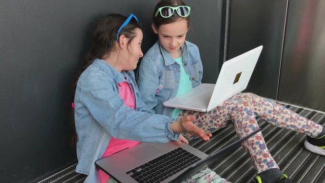 Little girls working together on laptop.