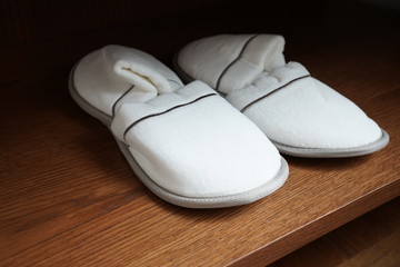 Hotel carpet slippers on a shelf in a closet