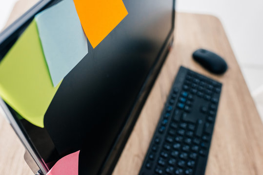 High Angle View Of Colorful Post Its On Blank Computer Monitor At Table