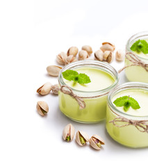 Natural  pistachio yogurt in a small glass jar isolated on white