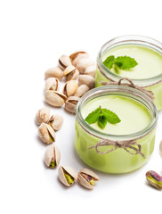 Natural  pistachio yogurt in a small glass jar isolated on white