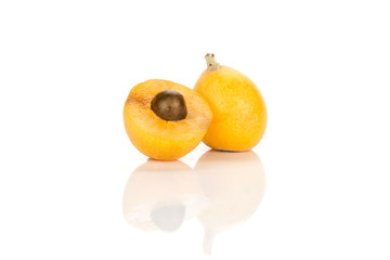 Fresh orange Japanese loquat and one sliced half with a seed inside isolated on white background.