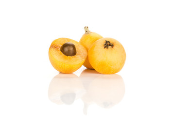 Fresh orange Japanese loquat set two whole and one half with a seed isolated on white background.