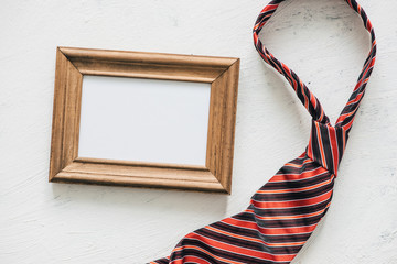 Naklejka premium Flatlay, necktie and blank frame. Father's day concept