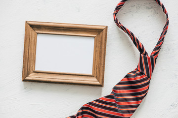 Flatlay, necktie and blank frame. Father's day concept
