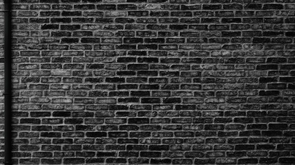 Naklejka na ściany i meble Black brick wall with drain pipe - urban grunge background