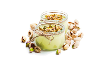 Natural  pistachio yogurt in a small glass jar isolated on white