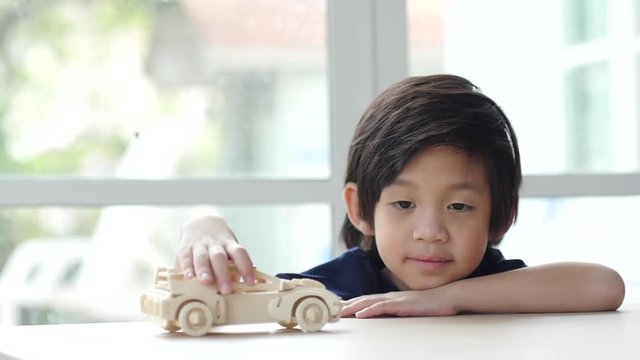 Cute asian child playing wood model cars slow motion 