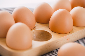 Close-up view of raw chicken eggs in egg box on white background