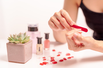 Obraz na płótnie Canvas women manicure and attaches a nail shape during the procedure of nail extensions with gel at home. Fashion and Beauty concept
