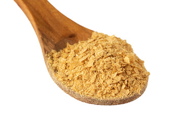 Nutritional brewers yeast flakes in wooden spoon isolated on white background