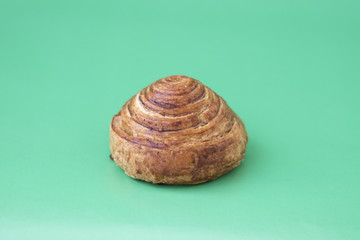 Bun with cinnamon close-up on a light green background