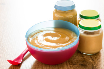 Baby food: colorful bowl of fruit puree on wooden table