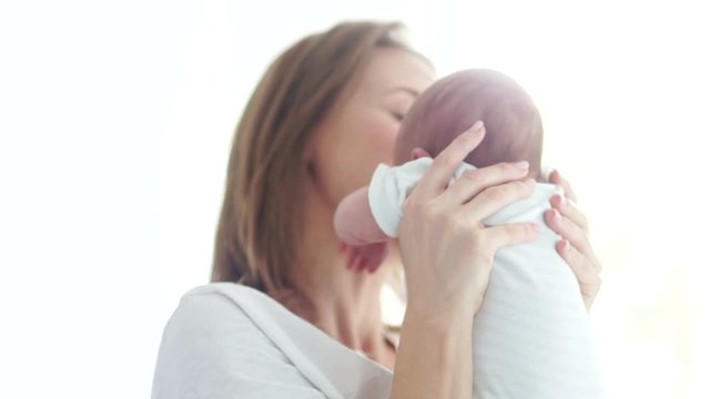 A young beautiful mother hugs her three-week-old baby. Mother and child. Surrogacy. Mothers Day