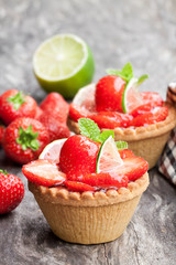 Egg custard  tarts with fresh strawberry and lime on wooden table