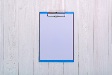 clipboard with blank white paper sheet on wood table top view with copy space.