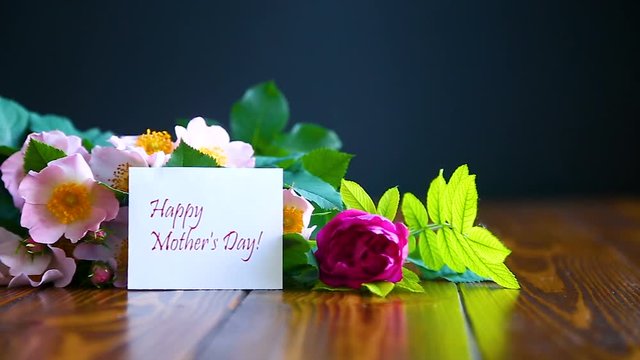 beautiful blooming roses and a greeting card for the mother