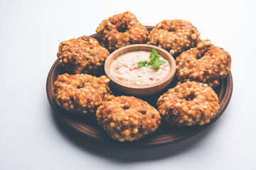 Sabudana vada or Sago fried cake served with peanut chutney over moody background, popular fasting recipe from India. 