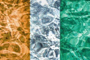 Texture of Cote d'Ivoire h flag in the pool, water. Circles on the water.
