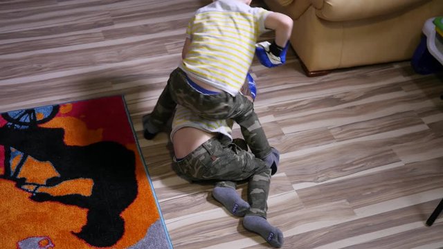 Twin kids boys have fun enjoy playing fighting with boxing gloves at home