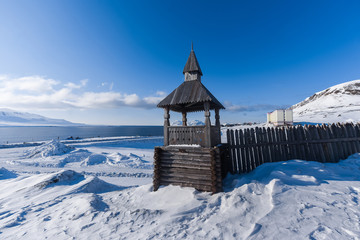Fototapeta na wymiar Landscape of the Russian city of Barentsburg on the Spitsbergen archipelago in the winter in the Arctic In sunny weather and blue sky