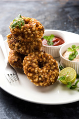 Sabudana vada or Sago fried cake served with peanut chutney over moody background, popular fasting recipe from India. 