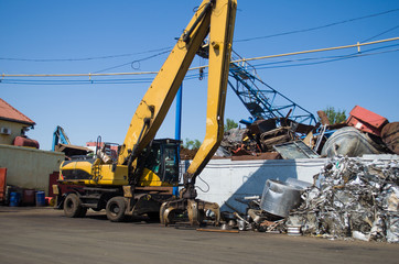 machine loader manipulator with hydraulic multivalve crab bucket uploads waste steel into a truck