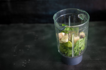 Preparing smoothie with spinach, kiwi, banana and chia