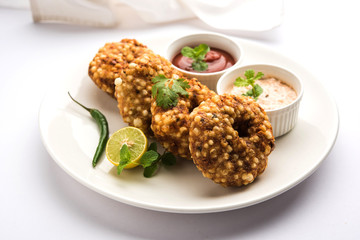 Sabudana vada or Sago fried cake served with peanut chutney over moody background, popular fasting recipe from India. 