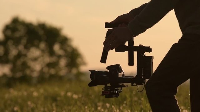 Video Camera Operator. Videography Theme. DSLR Camera on the Gimbal Stabilization Device. Film Production. Slow Motion Footage