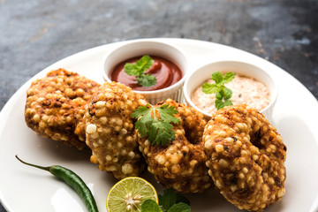 Sabudana vada or Sago fried cake served with peanut chutney over moody background, popular fasting recipe from India. 