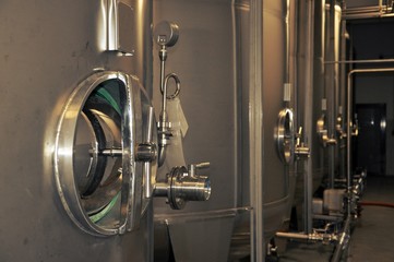 Wine tap of a fermenters steel tanks, winery modern equipment, closeup, indoor