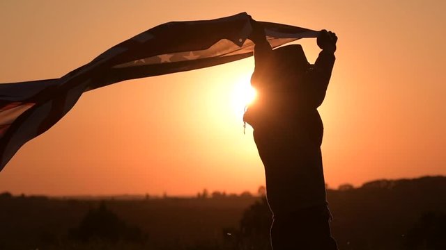 Slow Motion Footage of Caucasian American Cowboy Patriot Running with Flag During 4th of July Independence Day Sunset.