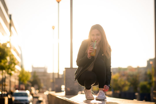 Woman drinking juice with straw in street