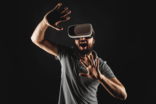 bearded man wearing virtual reality. Studio shot. Black background