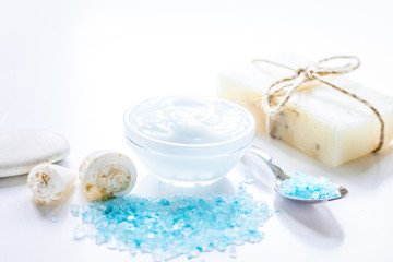 Fototapeta na wymiar spa composition with blue sea salt and natural soap on white des