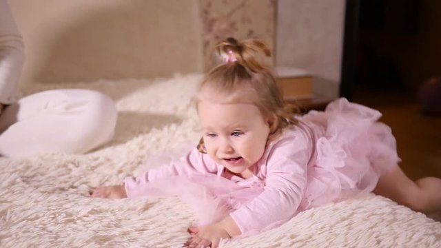 Little baby girl toddler play at home crowling back from a bed