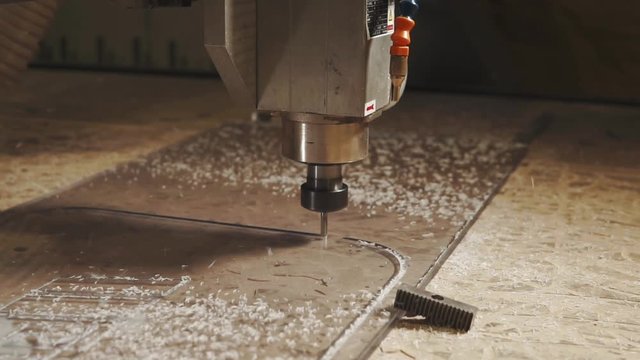 close up shot of an electric milling machine that is engaged in cutting out details from the glass surface in the factory, this machine has a numerical program control