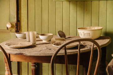 Interior of an old house, more specifically, a kitchen table, and two chairs,  in the Abandoned Ghost Town of Bodie, California. 