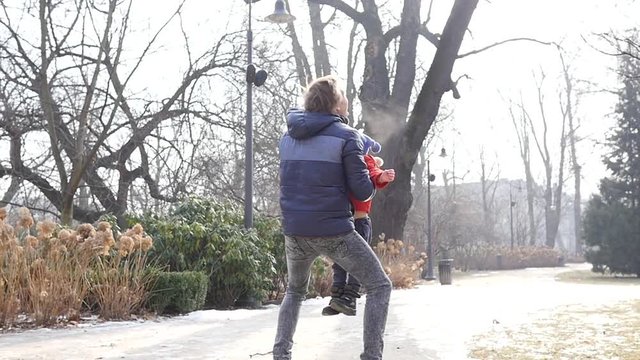 Family nature walk weekend - father throw toss up in air and catch little child boy son