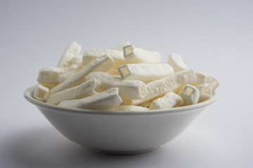 Kaju Katli is a Diamond shape Indian sweet made using cashew sugar and mava, served in a plate or bowl over moody background. selective focus