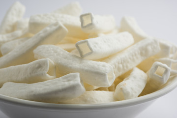 Kaju Katli is a Diamond shape Indian sweet made using cashew sugar and mava, served in a plate or bowl over moody background. selective focus