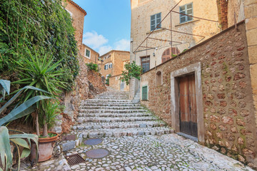 Fototapeta na wymiar Stone street and houses in Fornalutx town. Old charming mediterranean village in Majorca island.