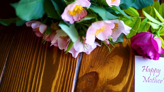beautiful blooming roses and a greeting card for the mother