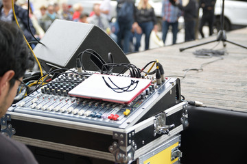 Sound engineer and the digital mixing console in a street show. Empty copy space for Editor's text.