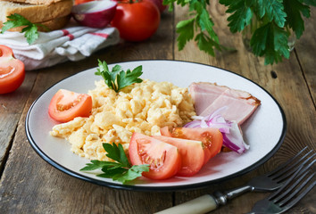 Scrambled eggs with vegetables and meat on a plate